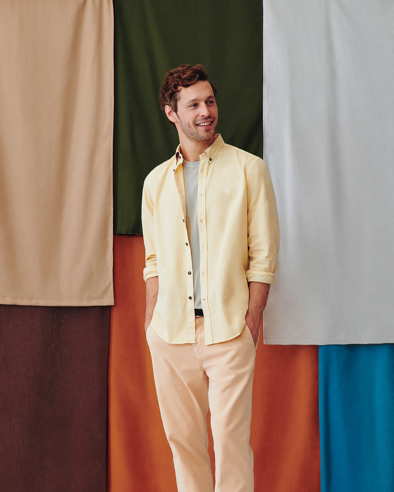 Male model wearing a peach shirt and female model wearing an olive green cardigan and pink t-shirt.