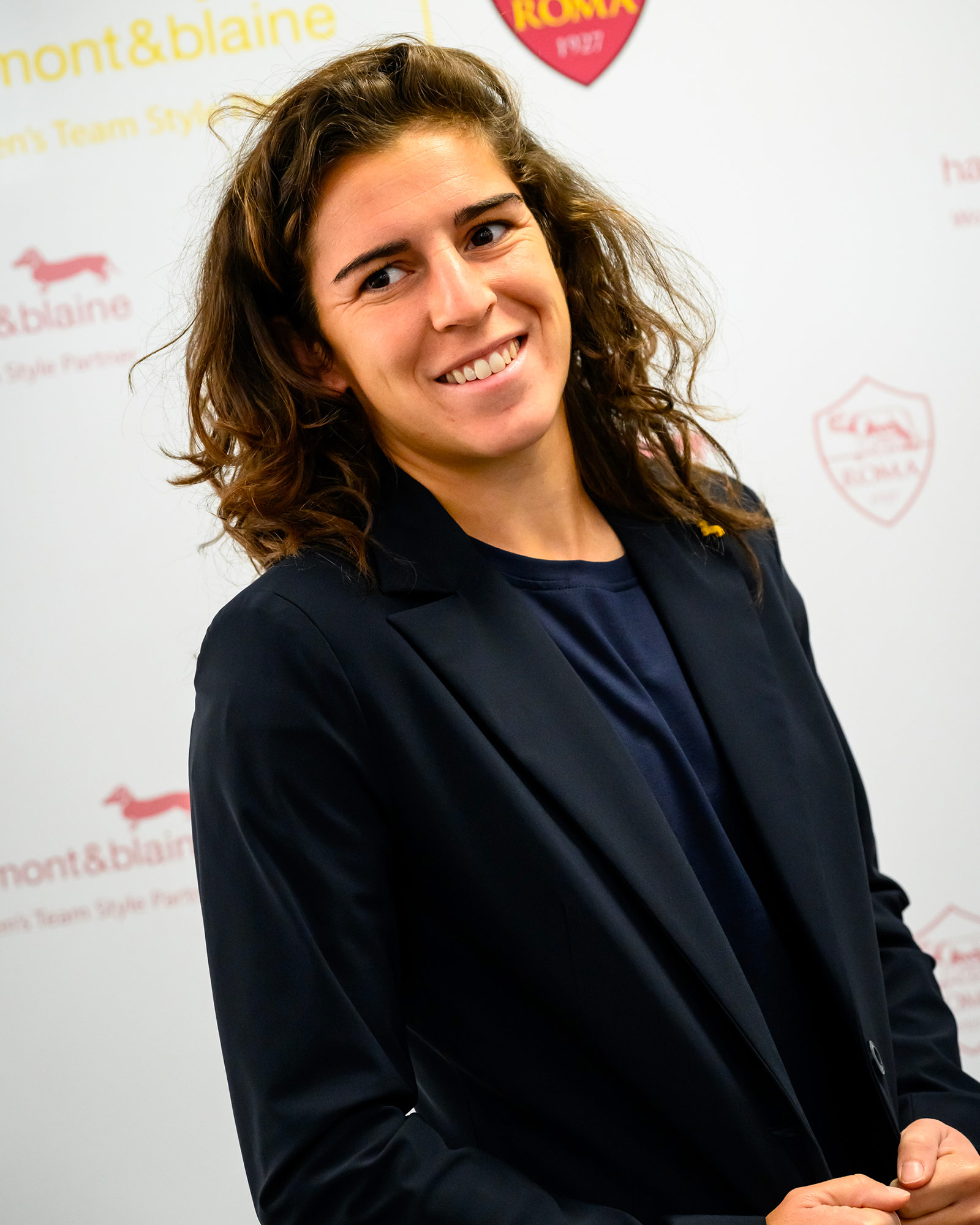 Woman wearing a navy blue blazer and blue top.