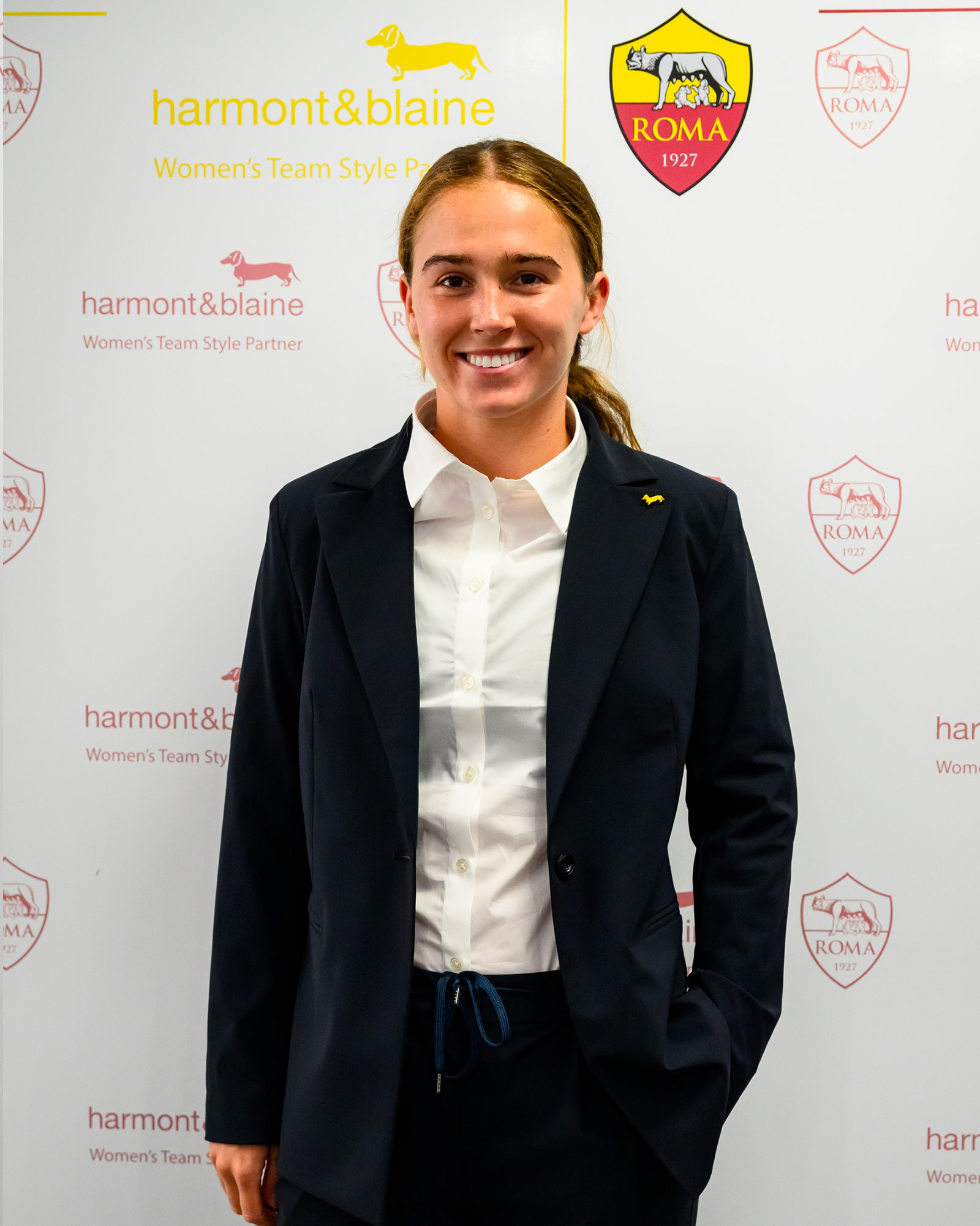 Woman wearing a navy blue blazer and white shirt.
