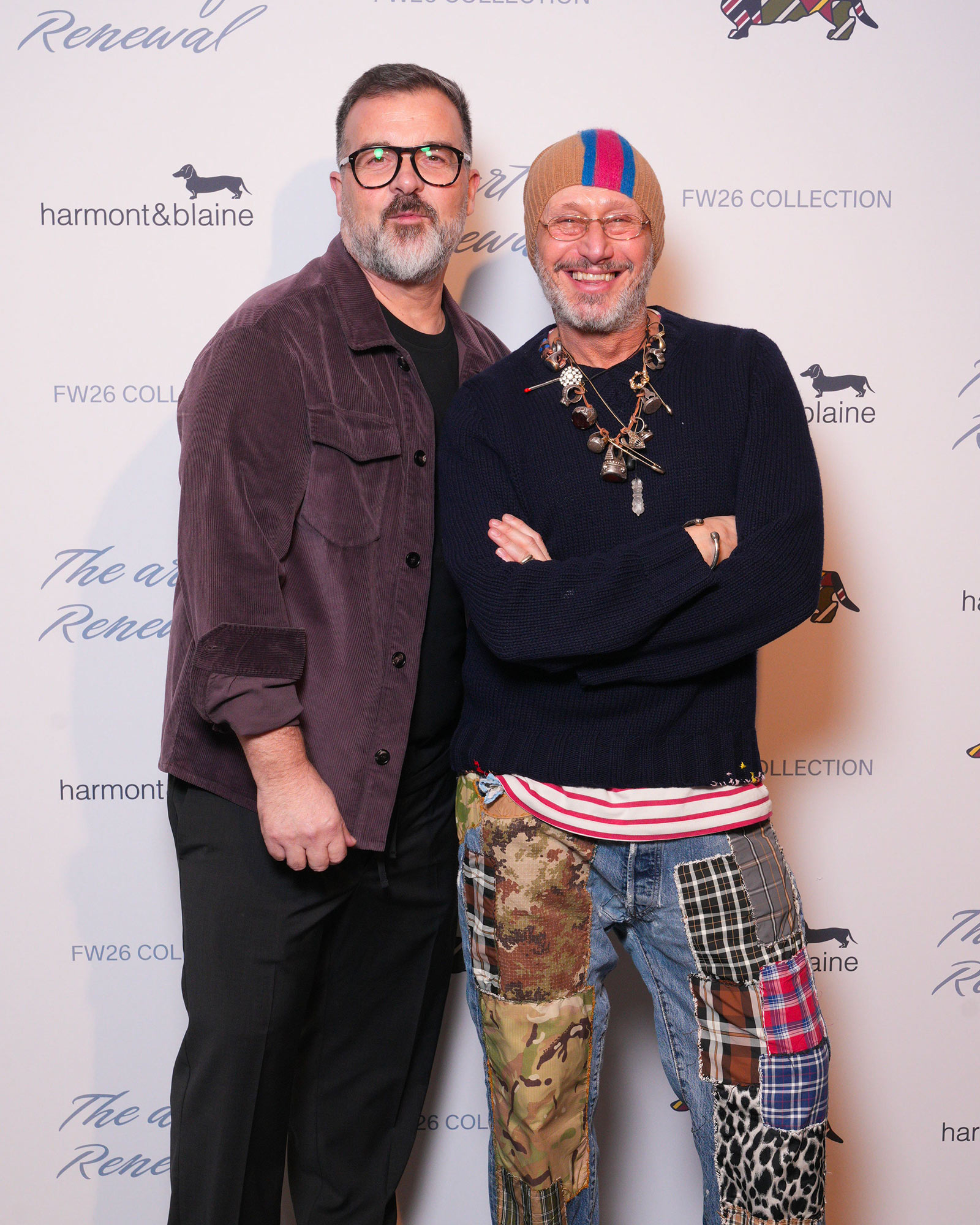 Two men in casual looks, one in purple cord jacket, the other in navy knit and patchwork trousers
