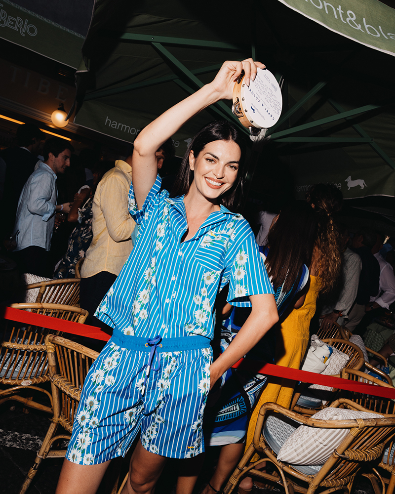Woman in blue summer set dancing with tambourine in Capri.
