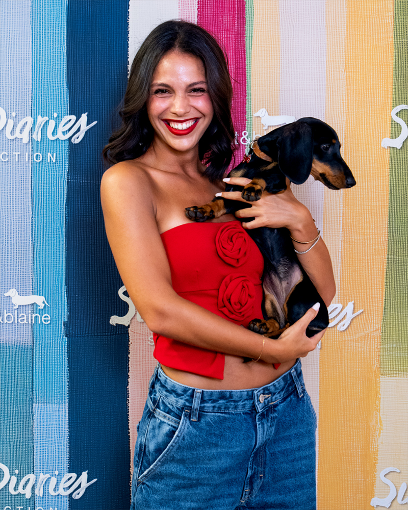 Mujer con top rojo y perro en el evento Summer Diaries.