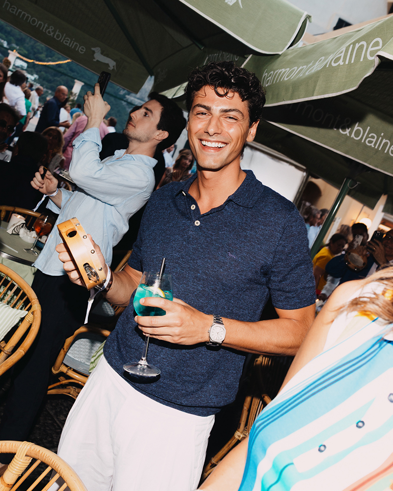 Hombre sonriente con c&oacute;ctel en el evento Harmont & Blaine en Capri.